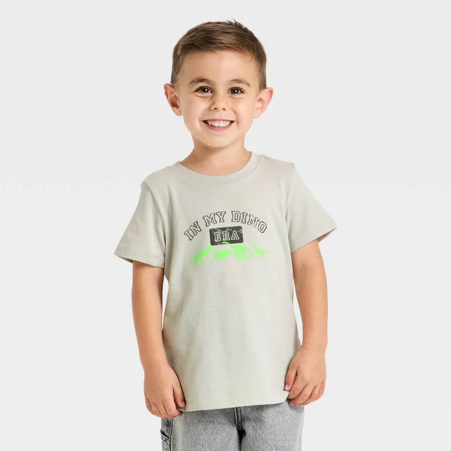 Smiling child wearing a Cat & Jack graphic tee and jeans on a neutral studio background